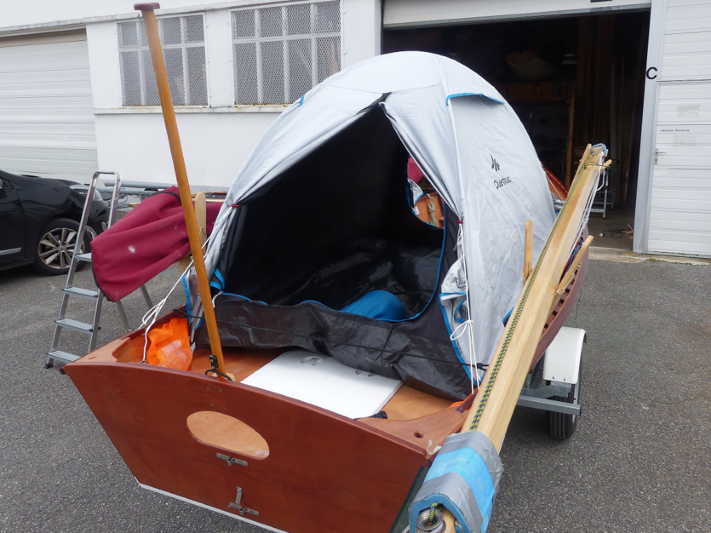 L'empreinte de la tente fait 210 cm par 120 cm, ce qui tient pile-poil sur la plateforme. Elle est tenue au bateau par 4 haubans amarrés sur la serre. J'évite de planter les sardines quand elle est dans le bateau.