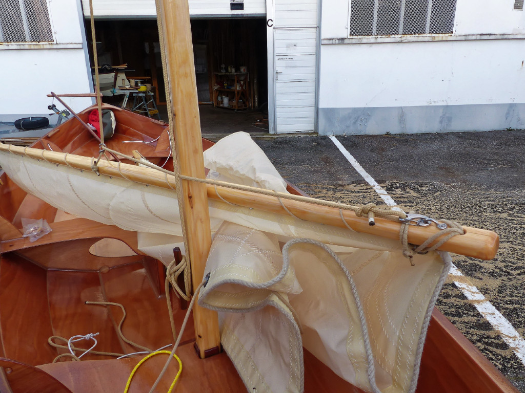 Gros plan sur la pointe avant de la vergue; avec le mousqueton du bout de la drisse et le pontet sur lequel il est frappé.