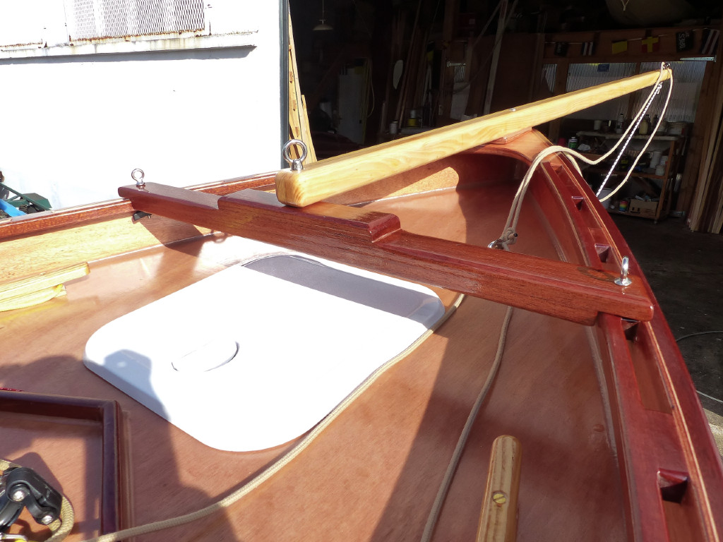 J'ai longuement cogité sur le système de fixation du bout-dehors et j'ai finalement opté pour cette pièces transversale amovible qui tient dans la serre ajourée par deux pitons à vis dont l'écrou à oreilles est placé dessous afin de ne pas accrocher les écoutes de foc. Afin de pouvoir de monter-démonter sans outils, j'ai utilisé des pitons à oeil. L'oeil rond accrochera moins les écoutes que les cornes de l'écrou papillon. Le bout-dhors est fixé sur la guirlande et sur le milieu de la pièce transversale par un autre piton à vis dont l'écrou à oeil est sur le dessus, toujours pour la facilité de montage-démontage sans outils. 