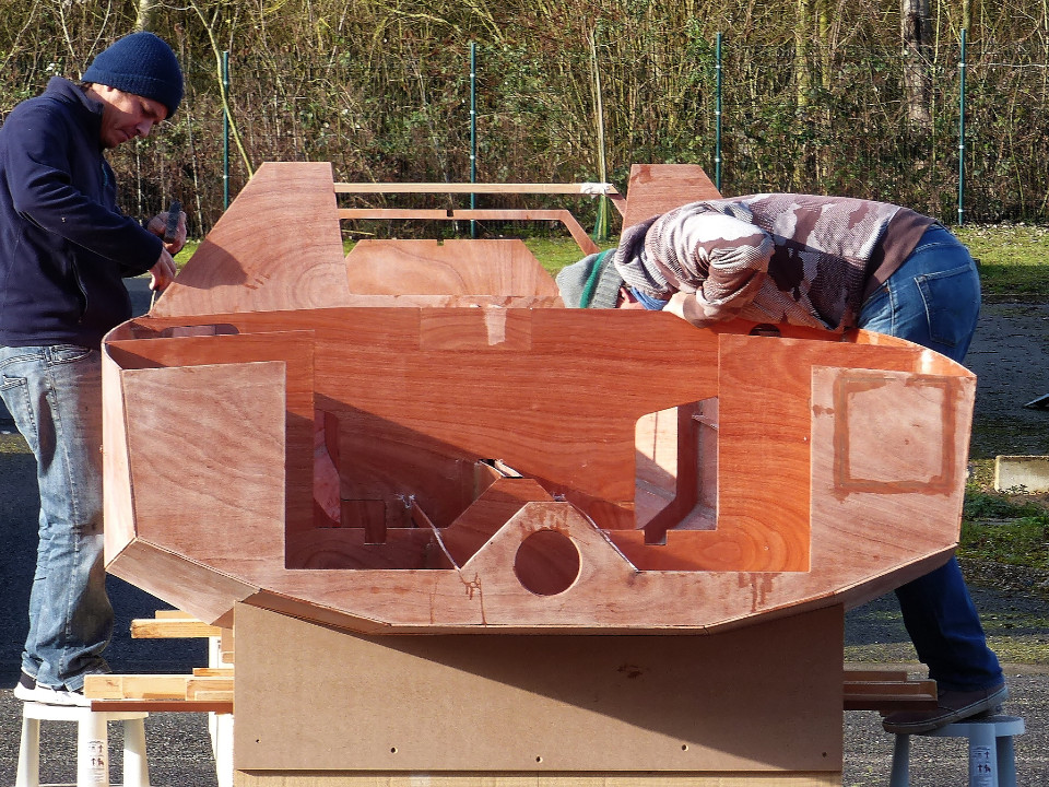 Le bau maximum de 1.75 m est à peine refermé au tableau arrière, ce qui donne un arrière large et porteur prometteur de belles capacités de planing au portant. Notez la petite trappe dans le tableau sur tribord : elle permet de ranger les avirons sous le siège tribord. William ne souhaitant pas utiliser cette possibilité, nous avons collé la trappe. Le trou rond au centre du tableau donne accès au écrous de fixation des ferrures de gouvernail, comme nous le verrons plus loin.