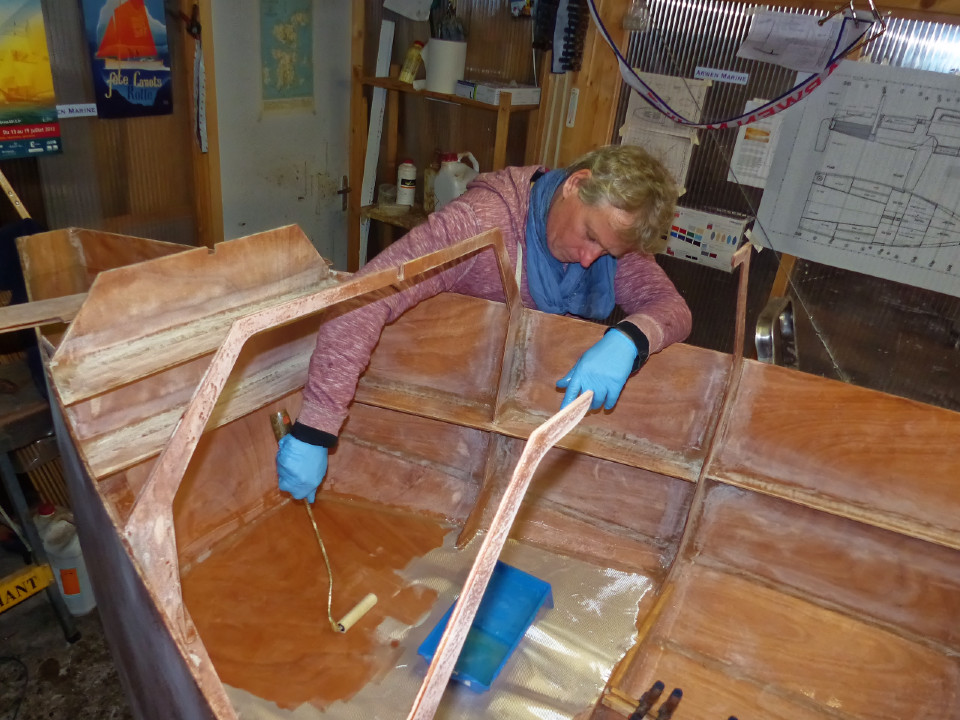 William utilise le rouleau pour saturer le tissu de verre d'époxy