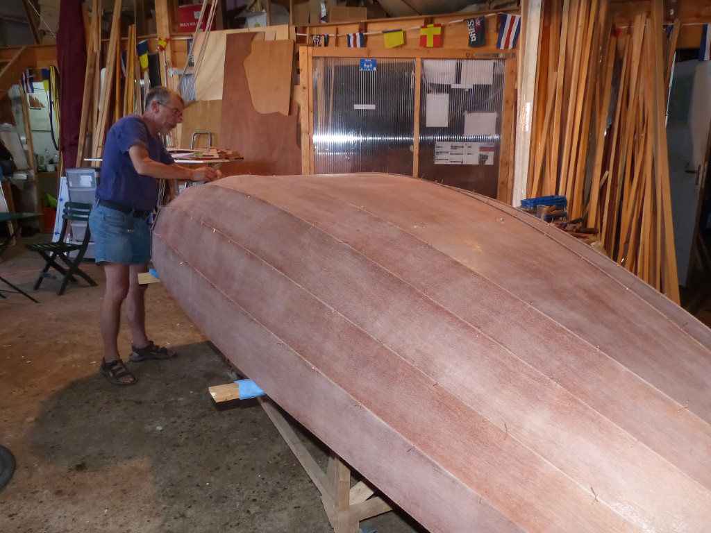 Nous avons retourné la coque afin de resserrer toutes les sutures avant le collage. Nous travaillons à l'intérieur, volet fermé, pour nous abriter de la petite canicule de ce début juin. Un mois plus tard, c'est bien oublié... 