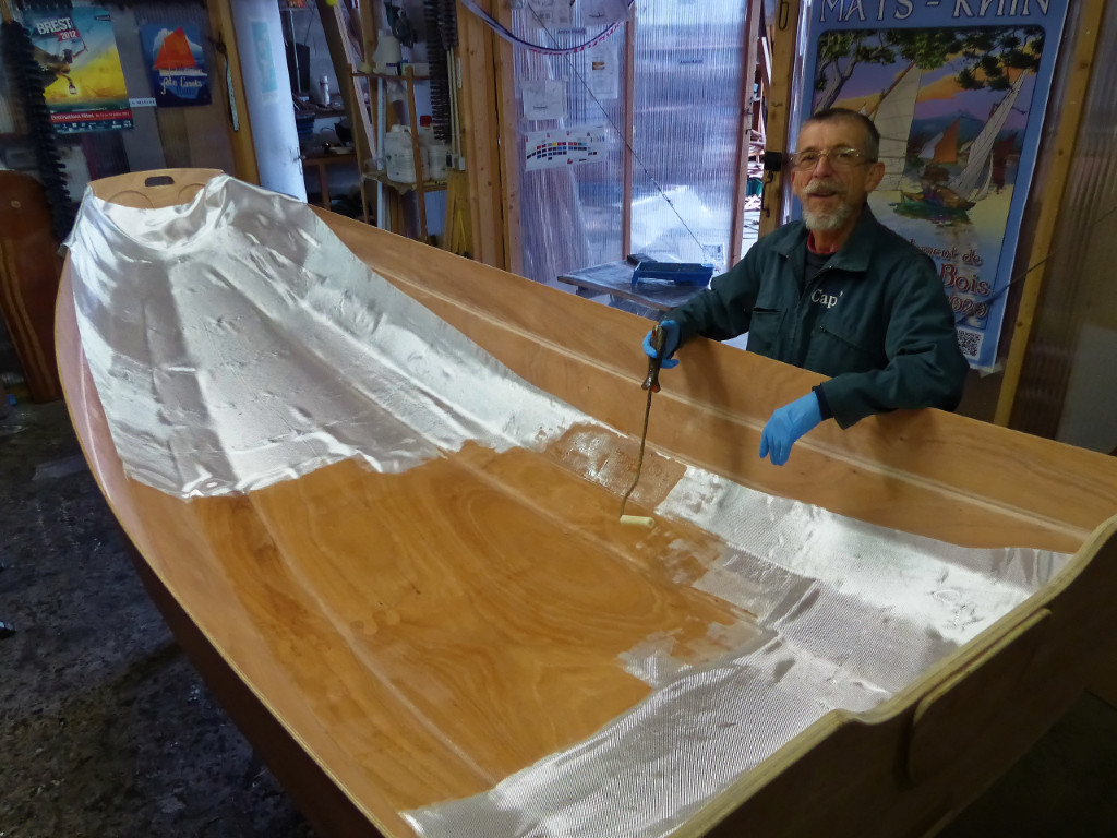 Saturation du tissu de verre à l'époxy afin de faire un composite bois-verre-époxy.