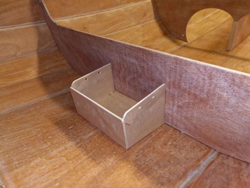 J'ai remonté les cloisons et j'ajuste les angles du caisson qui recevra la batterie d'un futur moteur électrique, réalisé lui aussi en cousu-collé, comme en témoignent les sutures visibles sur les arêtes. Je dois avouer que j'ai aussi utilisé de la Superglue en complément des sutures. 