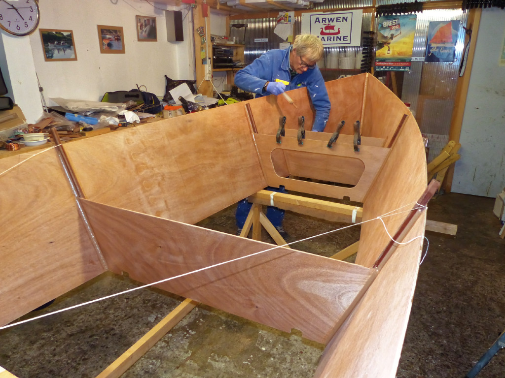 Pierre dépose un clombin d'époxy chargée le long de tous les points de contact des panneaux latéraux et des éléments transversaux, puis nous lissons des joints-congés partout. 