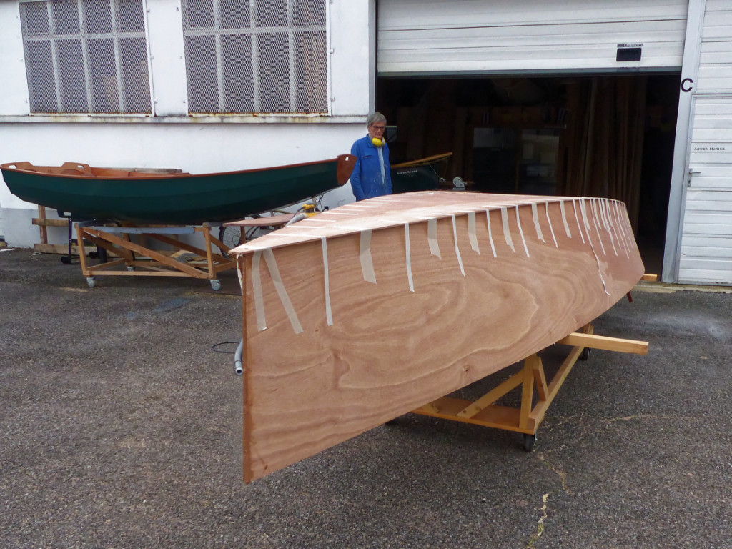 Une fois l'époxy durcie, nous reposons la coque sur le chariot et la sortons afin de couper l'excédent de contreplaqué sur les côtés de la coque. 