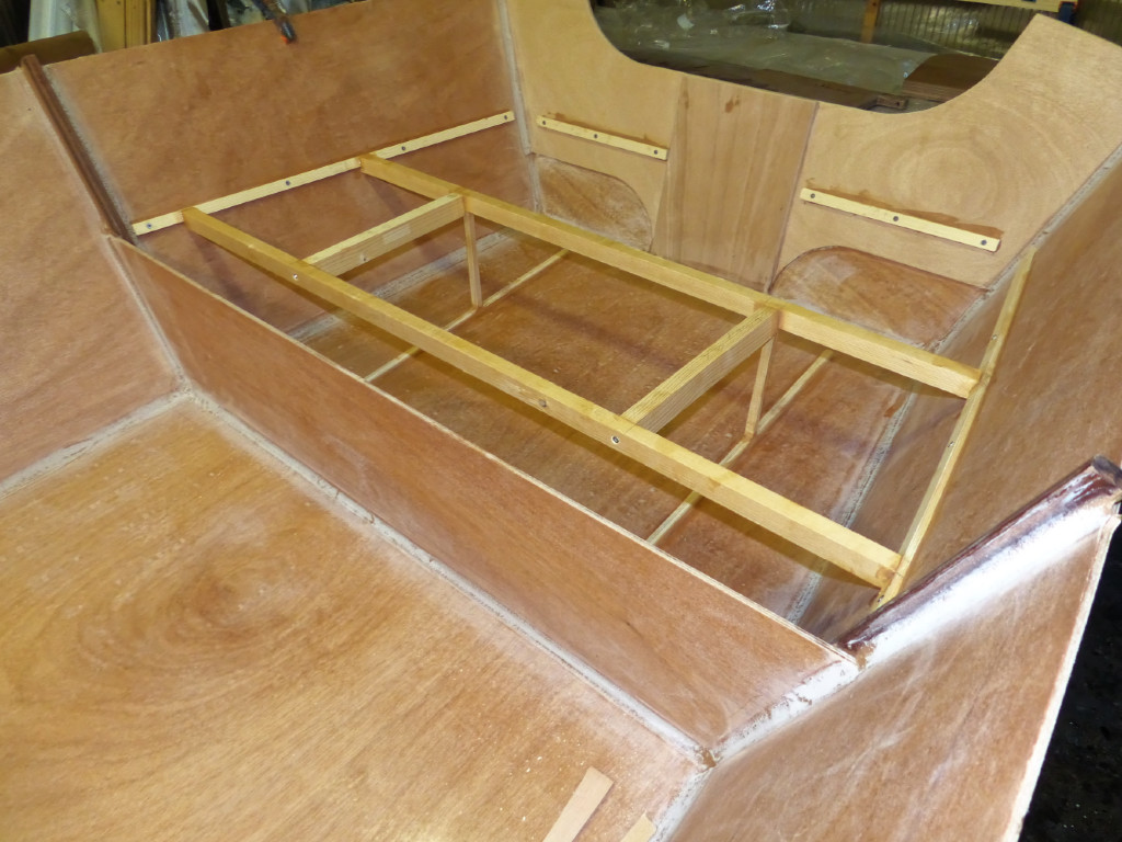 Les longerons sur la sole répartissent la pression des "jambes" qui soutiennent le barrot arrière. En effet, le dessus du compartiment arrière est en CP de 6 mm comme tous les panneaux du GIS, et il a besoin d'être soutenu. On voit que nous avons doublé le tableau arrière en 6 mm sur l'essentiel de sa surface, et ajouté un renfort central de 9 mm afin de le rigidifier pour pouvoir supporter la pression d'un moteur pour les partie pêches prévues par Pierre avec ses petits-enfants. 