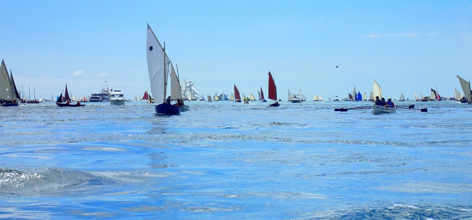 Ma Nemesis n'est pas loin : on voit ma voile rouge au centre-droite de cette photo de Ronan, avec un h&eacute;licopt&egrave;re en approche &agrave; droite... Mais je m'en tirerai bien cette fois-ci, je n'ai apparemment rien fait pour m'attirer la col&egrave;re des dieux de l'Olympe (et des autres, d'ailleurs) ! 