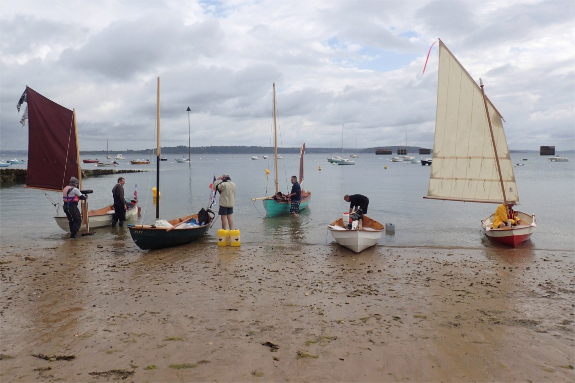Trois nouveaux bateaux se sont joints &agrave; nous : les deux Skerry "Chasse-Mar&eacute;e" de Didier F. et "Piff" de Jean-David, tout aur&eacute;ol&eacute;s de leur r&eacute;cente participation &agrave; Sail Caledonia, et le Drascombe "Divergont" de Didier C., invisible sur cette image. D&eacute;tails int&eacute;ressants : &agrave; gauche, Didier d&eacute;monte son chariot de mise &agrave; l'eau et au centre droit G&eacute;rard remplit ses bidons de ballast liquide (on voit ceux de Jean-David, jaunes, &agrave; ses pieds). Nous sommes abrit&eacute;s par l'Ile Longue et ne pouvons pas juger du vent r&eacute;el sur rade. 