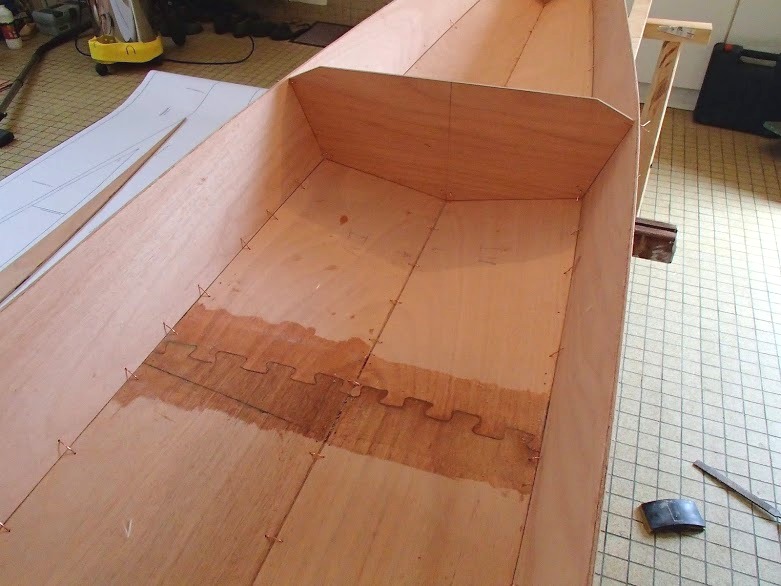 Voici la jonction des panneaux de fond, au centre du kayak. Le Shearwater 17 faisant 5.18 m de longueur, on ne trouve pas de feuilles de contreplaqu&eacute; &agrave; cette longueur (les feuilles de contreplaqu&eacute; standard font 2.44 m ou 2.50 m de longueur) et il faut donc juxtaposer deux &eacute;l&eacute;ments ou plus pour arriver &agrave; la longueur requise. Didier a d&eacute;coup&eacute; des joints-puzzle qu'il a coll&eacute;s sur chant, puis renforc&eacute;s en stratifiant une bande de fibre de verre d'une quinzaine de centim&egrave;tres de large. On aper&ccedil;oit les joints des panneaux lat&eacute;raux sur l'image pr&eacute;c&eacute;dente : pour obtenir la longueur n&eacute;cessaire, Didier a du juxaposer trois &eacute;l&eacute;ments. 