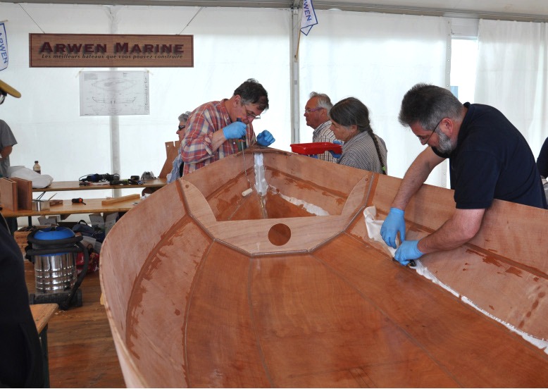 Une fois le tissu saturé d'époxy sur toute la surface de la sole et des bordés 1, je coupe au cutter l'excédent de tissu sur le joint entre le bordé 1 et le bordé 2. 