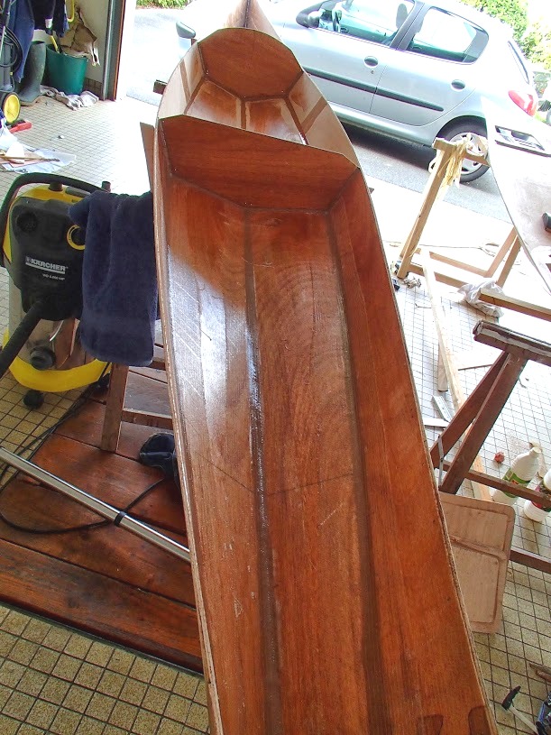 Apr&egrave;s avoir d&eacute;mont&eacute; le pont, Didier fait les joints-cong&eacute;s qui collent les panneaux de coque les uns aux autres et bloquent l'angle des ar&ecirc;tes le long de la ligne de quille et du bouchain, de part et d'autre. Toute la surface int&eacute;rieure a aussi re&ccedil;u une couche d'impr&eacute;gnation &eacute;poxy. Notez que les cloisons temporaires ont disparu et que des joints-cong&eacute;s ont aussi &eacute;t&eacute; faits sur tout le pourtour des deux cloisons restantes. 