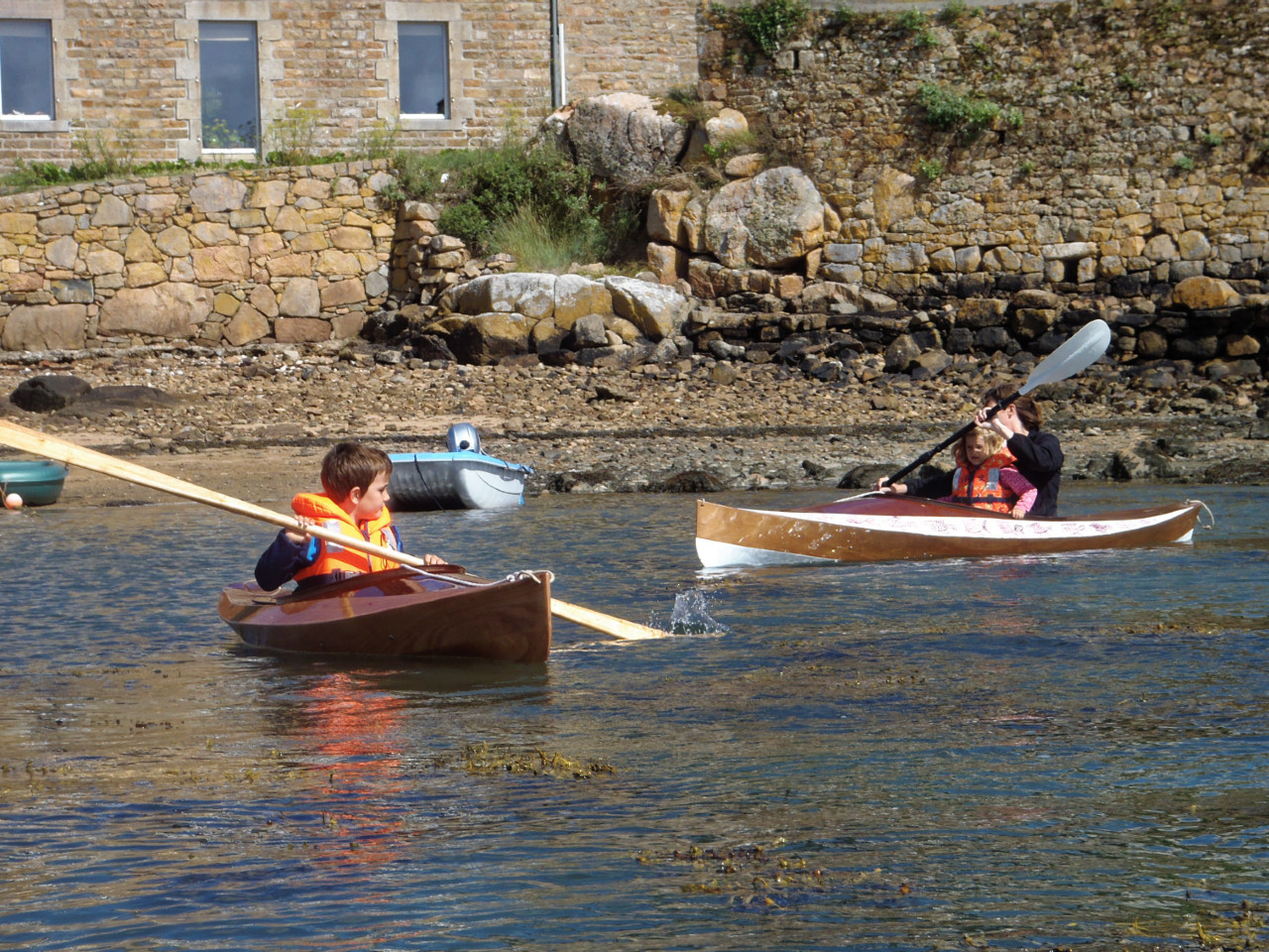 Nous sortons les kayaks : ici Adam (7 ans) teste le Wood Duckling (Duckling signifie caneton en anglais) et Alice emmène Jade sur ses genoux dans le Wood Duck 10, qui était déjà sur place. 