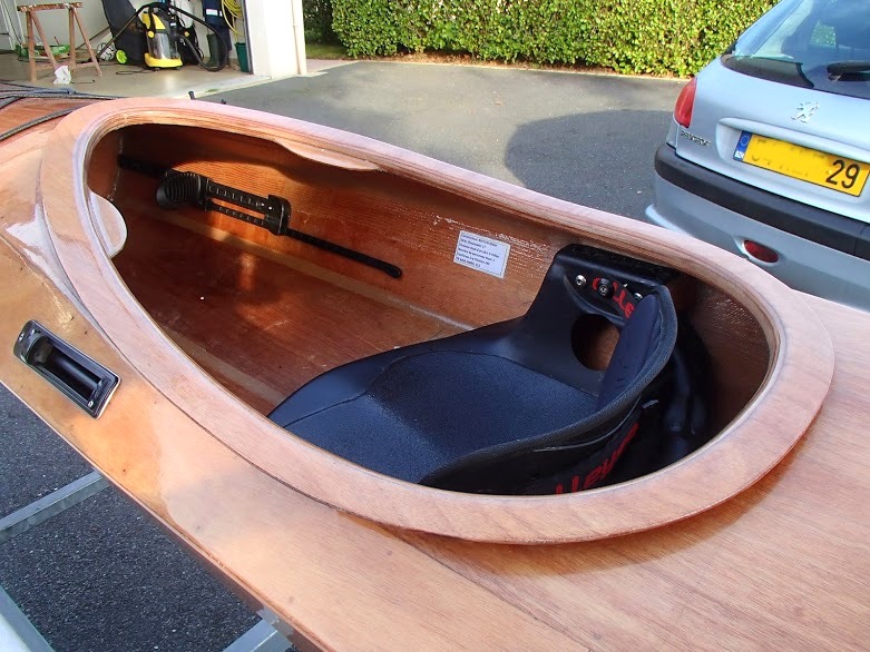 Vue du cockpit avec le si&egrave;ge, et on aper&ccedil;oit le cale-pied tribord sur son rail, ainsi que la plaque d'identification du kayak. 