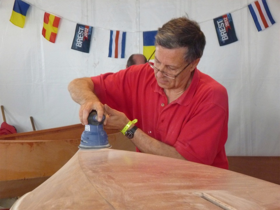 Michel utilise la ponceuse orbitale pour "effacer" le talon de la bande de renfort de l'étrave. 