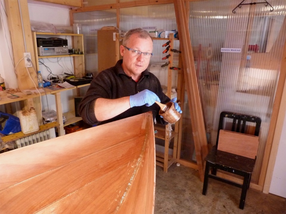 Herv&eacute; utilise un pinceau pour saturer d'&eacute;poxy la bande de renfort de l'&eacute;tambot. 