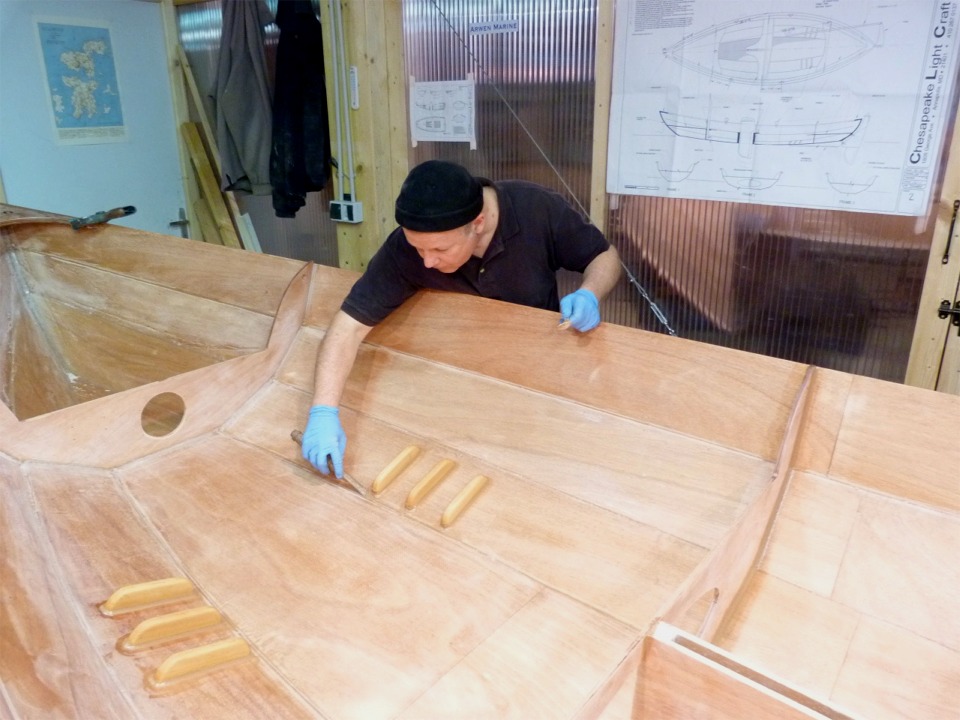 Nous venons de re-suturer en place la cloison centrale, puis nous avons fait les joints-cong&eacute;s sur sa face avant et arri&egrave;re, au contact avec le bord&eacute;, nous avons ensuite viss&eacute; et coll&eacute; le puits de d&eacute;rive, et enfin les trois paires de cale-pieds de nage. 