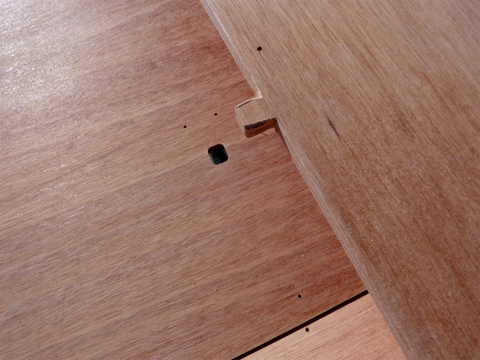 Gros plan sur l'une des deux mortaises dont sont munis les membrures avant et arri&egrave;re. On aper&ccedil;oit aussi les trous des sutures. Nous avons pass&eacute; un petit coup de lime rapide sur les ar&ecirc;tes verticales du tenon d&eacute;coup&eacute; dans le bas de la membrure afin qu'elle rentre plus facilement dans la mortaise, dont les angles sont arrondis. 