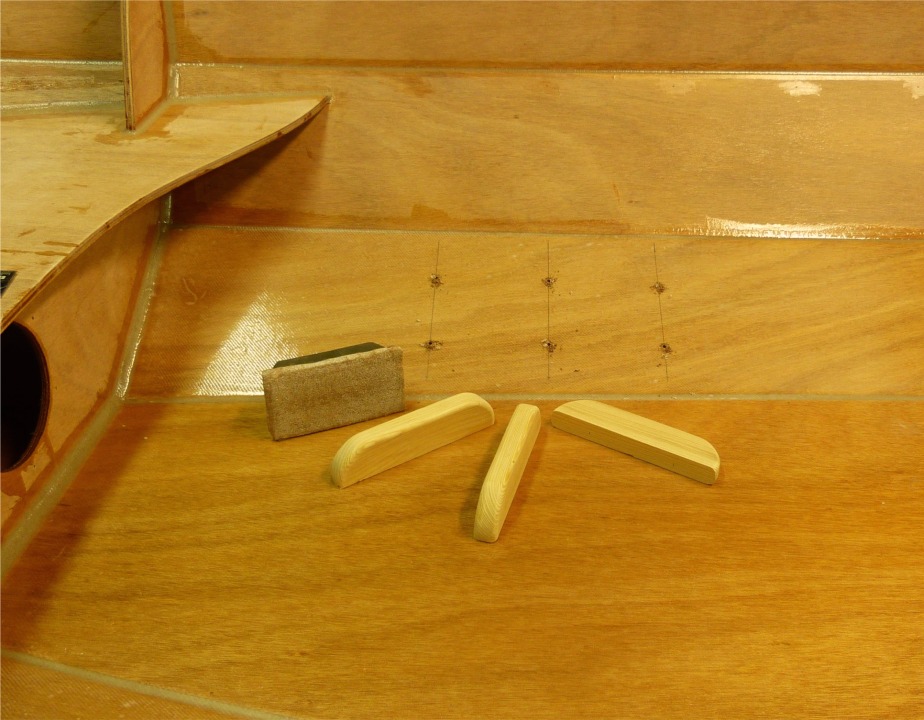 Voici les cale-pieds (ou cales-pieds, ou encore cales-pieds, damned !) J'ai d'abord pass&eacute; un petit coup de papier de verre afin de d&eacute;polir la surface : cela me permet de tracer plus facilement, et surtout, cela donne une accroche m&eacute;canique au collage qui vient. J'ai perc&eacute; par l'int&eacute;rieur et frais&eacute; par l'ext&eacute;rieur pour deux vis par cale-pied (il suffit de tourner la phrase pour passer au singulier). 