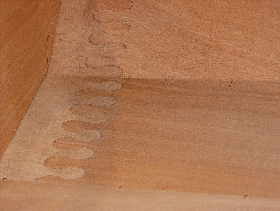 Gros plan sur le bordé 1 : on aperçoit le bord bâbord de la sole en bas, et le bord inférieur du bordé 2 en haut, juste en avant de la membrure centrale. Notez les sutures du joint entre le bordé 1 et le 2 : tous les trous dans le bordé 2 sont accompagnés d'un jumeau, car j'avais mal positionné le bordé pendant le reportage, et il était trop avancé. J'ai tout défait et recousu ensuite. 