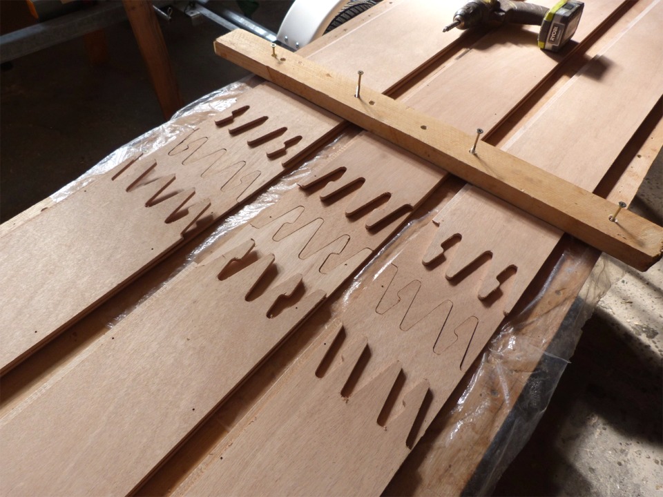 En effet, les bord&eacute;s sont coup&eacute;s dans des feuilles standard de contreplaqu&eacute; marine okoum&eacute; de 2.50 m de longueur et il faut donc assembler deux demi-bord&eacute;s pour faire un bord&eacute;, ou plut&ocirc;t une virure si l'on veut &ecirc;tre pr&eacute;cis. Je vais encoller d'&eacute;poxy charg&eacute;e le chant de la d&eacute;coupe en puzzle, emboiter les deux parties (ici les demi-bord&eacute;s du dessous sont assembl&eacute;s pour v&eacute;rification) et presser les virures superpos&eacute;es par paire pour le collage. 