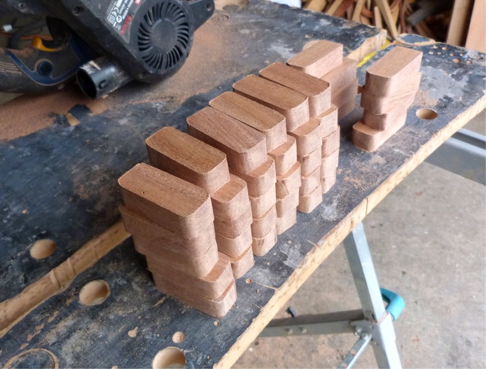 Evidemment, ma d&eacute;cision d'installer une serre sur cales ne va pas dans le sens de la simplification... Je commence par d&eacute;couper 38 cales de sapelli et j'arrondis leurs 4 angles. J'ajouterai encore deux cales apr&egrave;s avoir d&eacute;cid&eacute; d'ajouter une troisi&egrave;me position de nage (pour nager en simple ou en double). 