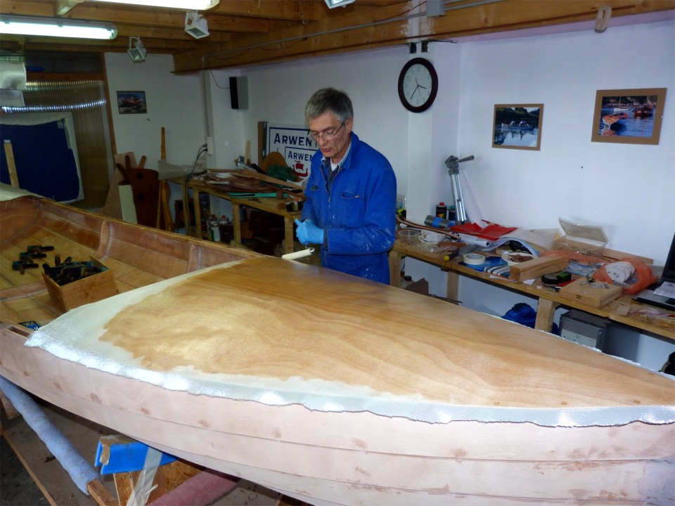 Pierre sature le tissu de verre au rouleau. Nous avons h&eacute;sit&eacute; &agrave; faire cette stratification, qui ajoute 500 grammes au poids de la yole, mais nous avons pr&eacute;f&eacute;rer "blinder", en particuler &agrave; l'avant, car le pontage diffusera les efforts du gr&eacute;ement.