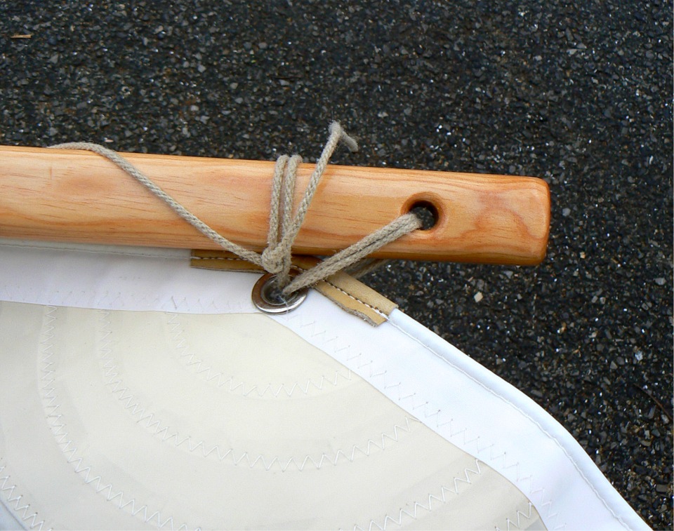 "Talon" de la vergue. Seuls deux des 4 brins de la ligature passent dans le trou, les deux autres passent autour de l'espar pour éviter de risquer de fendre. Les 4 angles de la voile sont saisis de la même façon.