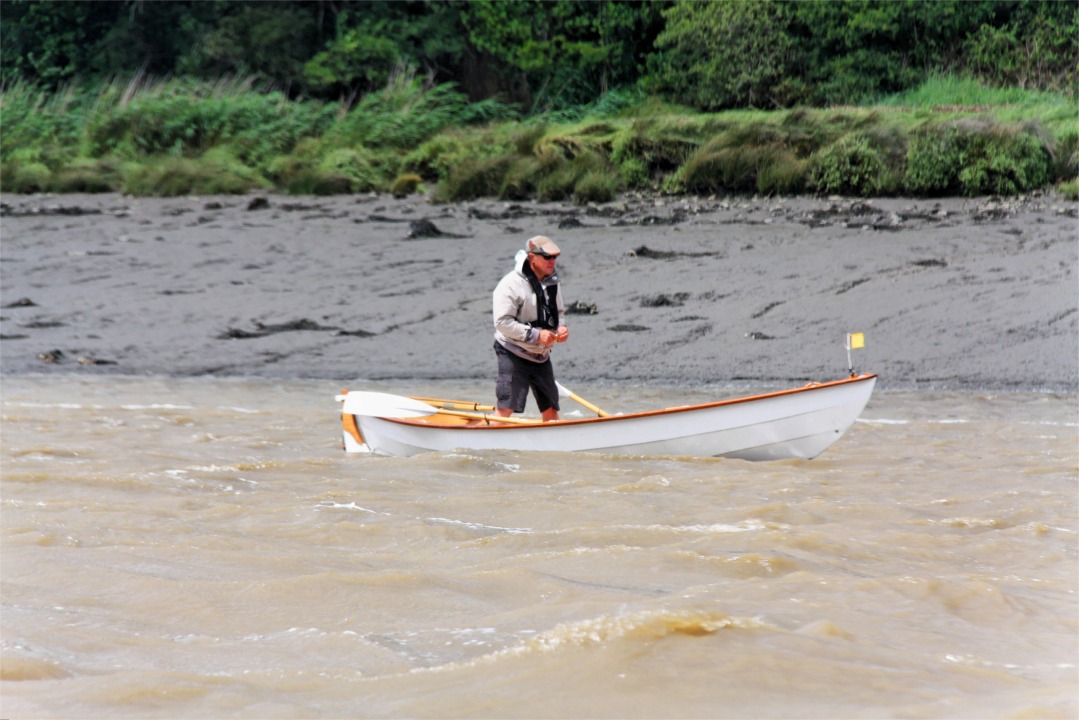 G&eacute;rard se met debout afin d'offrir plus de prise au vent et aller ainsi encore plus vite. Il barre avec les jambes. 
