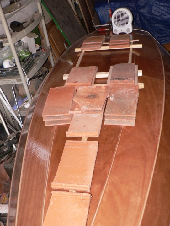 Les tuiles sont lourdes... et Richard s'en sert pour presser le collage de ses fausses quilles : une centrale entre l'étrave et le puits de dérive, et deux latérales. 