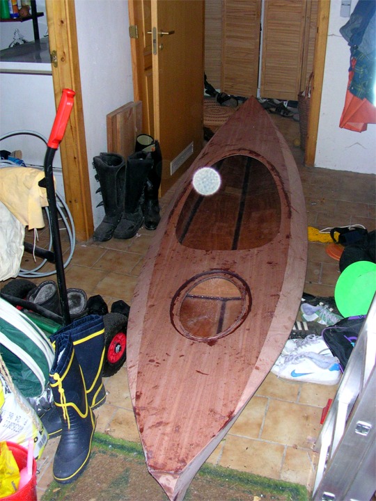 Reinhold a fini le plus gros de sa construction : il ne reste plus qu'&agrave; stratifier (coller le tissu de verre &agrave; la r&eacute;sine &eacute;poxy afin de r&eacute;aliser un composite avec le contreplaqu&eacute;). Mais auparavant, Reinhold doit poncer toute la surface du kayak qui sera ensuite fig&eacute;e &agrave; jamais sous le tissu de verre. La tache blanche est un gros grain de poussi&egrave;re sur l'objectif. 