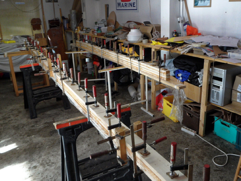 Et au premier plan, c'est la mât qui est en cours de collage, sur une latte en profilé d'aluminuim afin d'assurer que l'espar soit rectiligne après collage. 