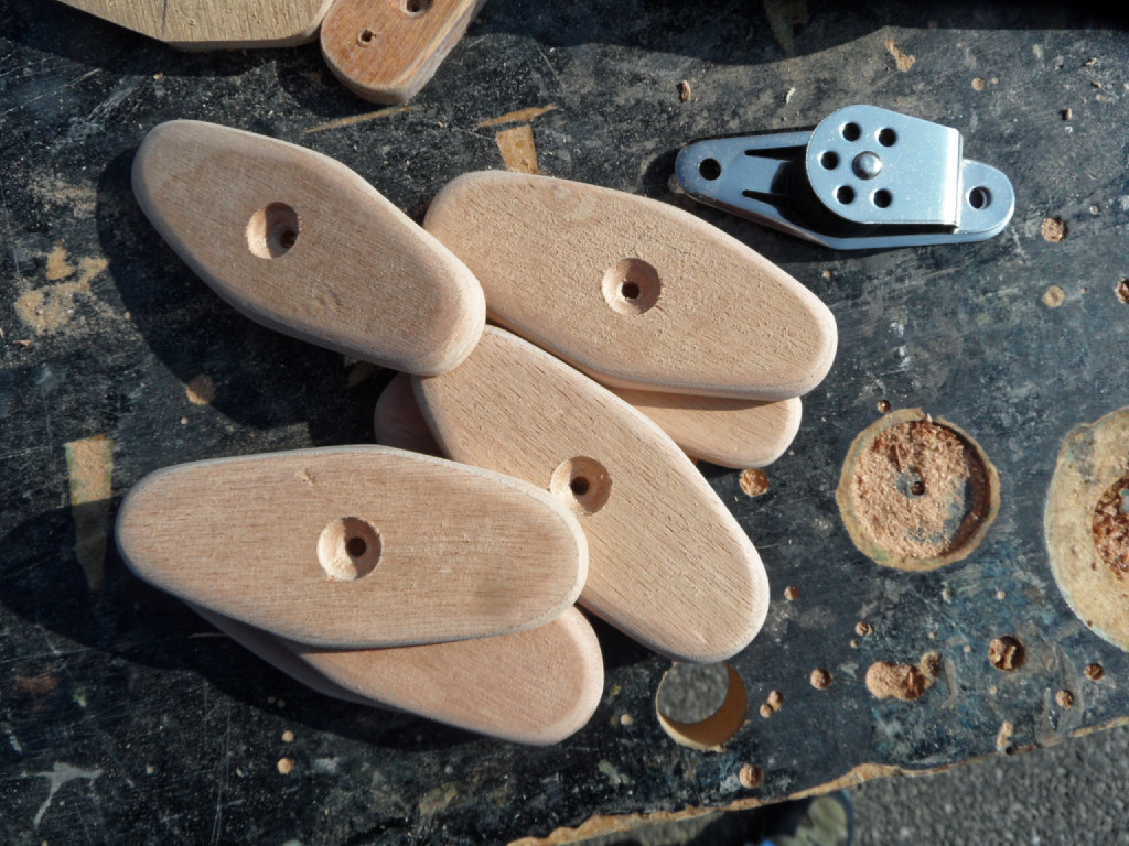 Le trou central fraisé permettra de passer une vis inox qui pressera et renforcera le collage à l'époxy. Son fraisage généreux permet d'abaisser la tête de la vis et de laisser un alésage pour l'axe de la poulie. Il reste encore à faire les deux trous des vis de fixation de la poulie de renvoi. 