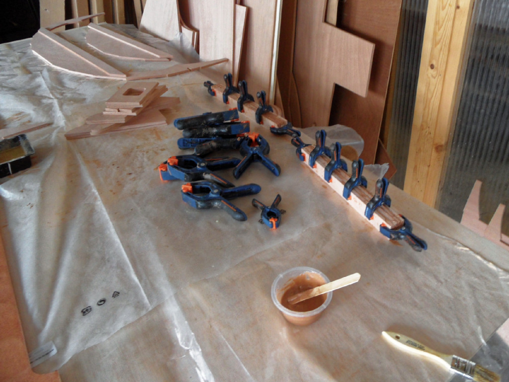 Nous commençons à coller lees pièces qui sont consitutées de pluisuers épaisseurs. Ici, ce sont les deux "jambes" du puits de dérive, constituées de 4 épaisseurs de CP de 9 mm. Tous ces collages sont faits à l'époxy, additionnée de charge à une consistence de vinaigrette. 