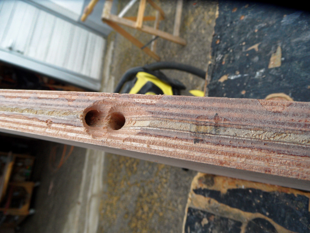 Nous faisons deus trous à travers l'âme du gouvernail afin de ménager un passage aux drisses de pivotement du safran. Ici, c'est la face avant de l'âme, juste sous la barre...