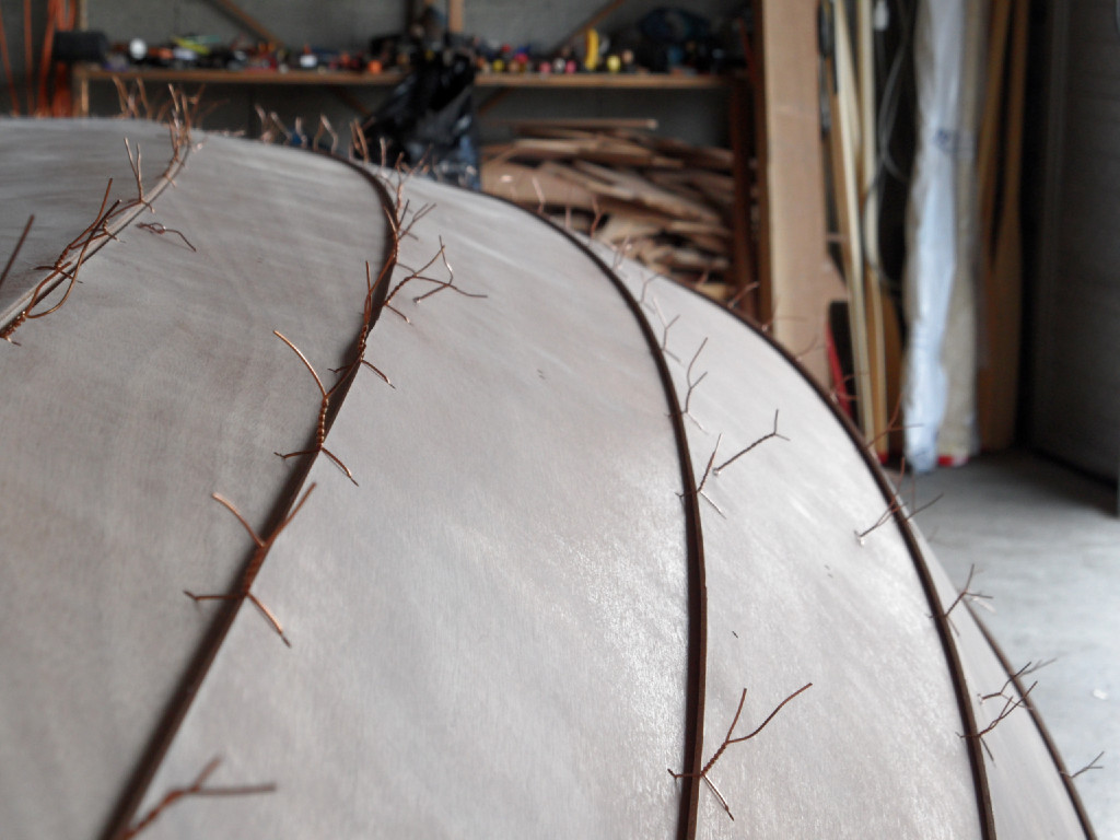 Le lendemain de ce premier collage, nous retournons la coque en vue du collage général des joints entre les virures. Cette photo montre comment nous avons positionné le "noued" de chacune des sutures : nous avons essayé autant que possible de le positionner sur l'arête basse de la feuillure, afin de minimiser l'indentation que crée le fil de cuivre lors du serrage de la suture. 