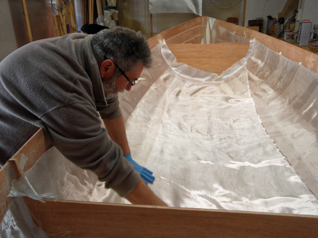 Dans le compartiment central, nous fixons le bord du tissu de verre juste au dessus du joint entre les virures 5 et 6 à l'aide de petits bouts d'adhésif de masquage et nous avons un important recouvrement sur le fond de la coque, qui couvre la sole, les virure N°1 et la moitié des virures N°2 au plus large de la coque. 