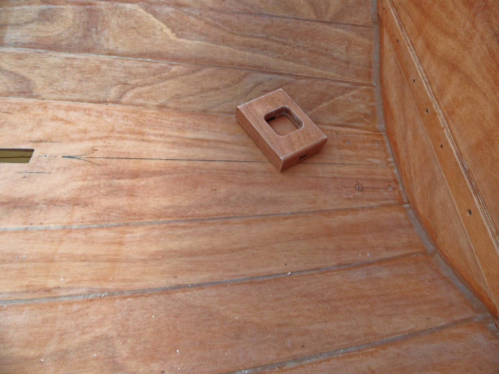 Marquage pour les 4 vis qui tiennent le pied de de mât sur la sole, en plus du collage à l'époxy. Notez que le pied de mât est pourvu d'une ouverture des deux côtés afin d'évacuer l'eau qui sinon stagnerait autour du pied du mât. 