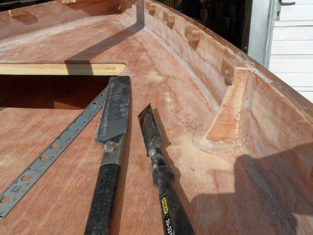 On voit que nous avons aussi vissé-collé les cales de la serre ajourée et la présence des scie montre que nous venons de faire les entailles dans les têtes des cloisons afin que serre puisse venir se poser sur les cales de part et d'autre. On considère en principe que l'espacement entre les cales est égal à la longueur des cales (50 mm), mais le calcul de la distribution des cales est un sujet qui prend du temps car on doit considérer séparément chaque intervalle entre deux cloisons (ou entre la guirlande et la cloisons 4 ou encore entre la courbe arrière et la cloison 1). De plus, il faut prévoir des doubles cales sous les supports de dames de nage, et comme il y en a trois paires à positionner... 